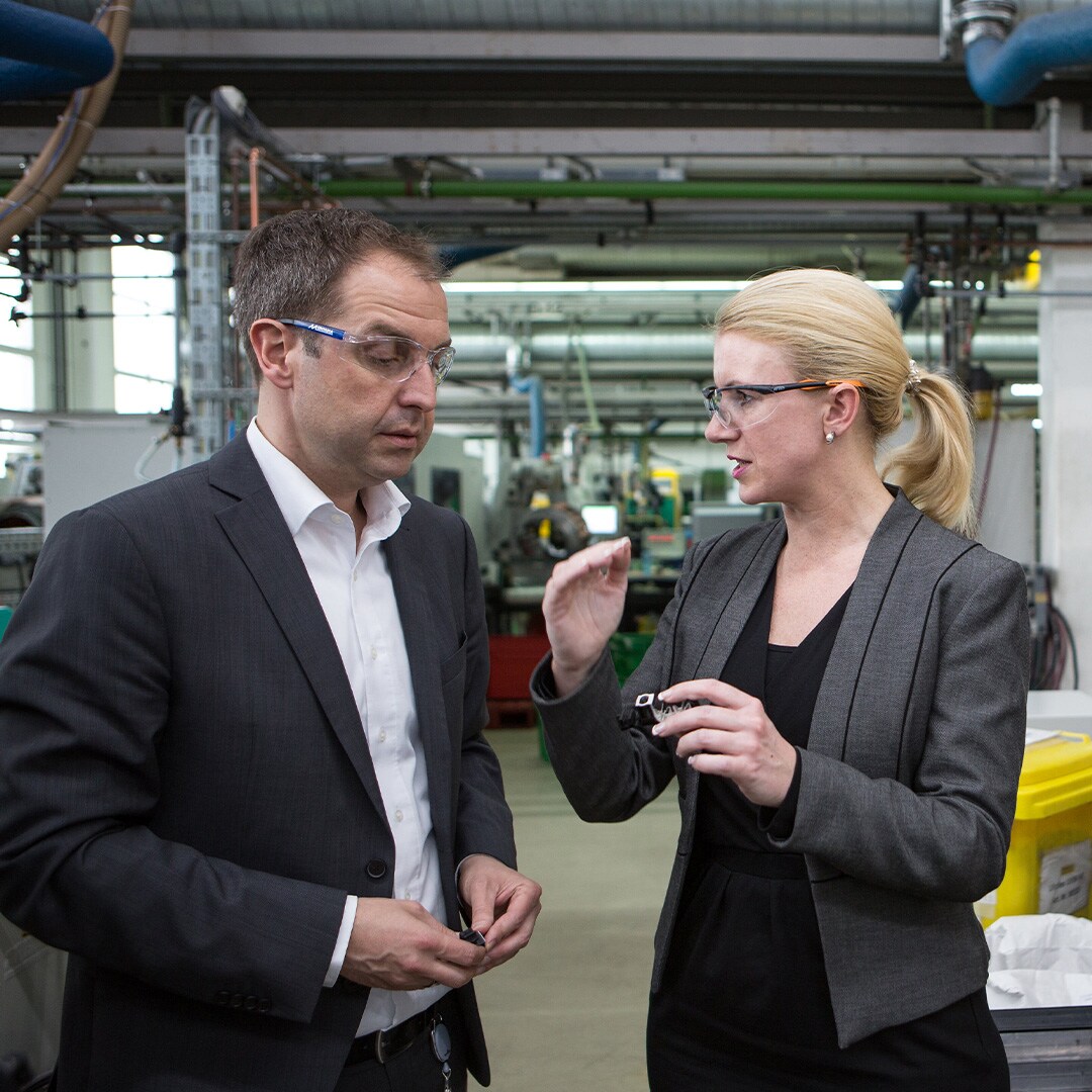 Two Stanley Black & Decker employees in discussion in a manufacturing facility