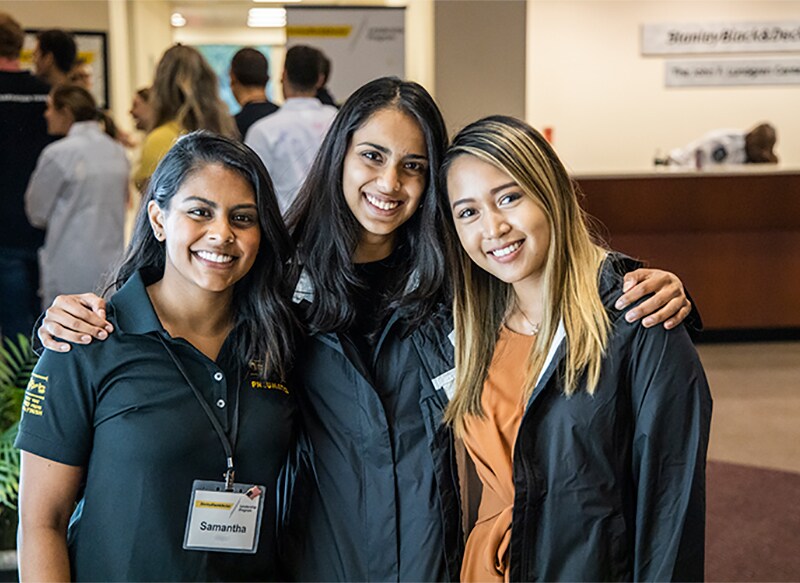 Three Stanley Leadership Program associates stand smiling