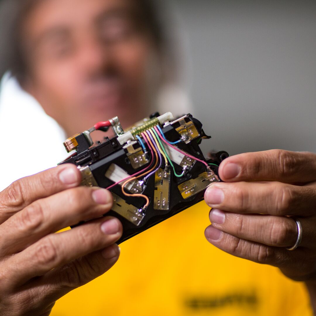 An engineer examining the interior of a DEWALT battery